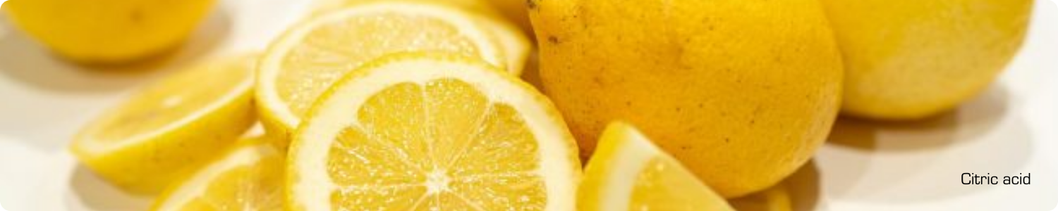 Verse, heldergele citroenen en sappige citroenschijfjes die de natuurlijke oorsprong van citroenzuur illustreren.