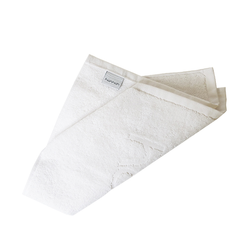 Een gevouwen witte katoenen hannah kompresdoek met een grijs merklabel op een witte achtergrond.