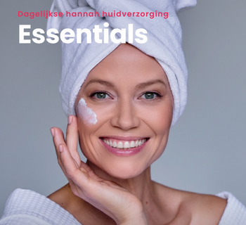 Lachende vrouw met handdoek op haar hoofd en crème op haar wang