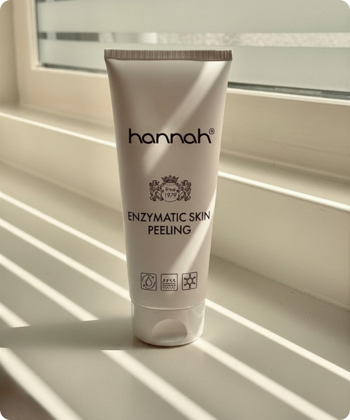 De verpakking van de hannah Enzymatic Skin Peeling staand op een vensterbank met schaduwval van luxaflex.