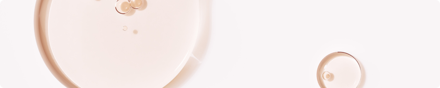Een abstracte en minimalistische weergave van lichtroze, transparante vloeistofdruppels en cirkels die de textuur van vitamine E als ingrediënt symboliseren.