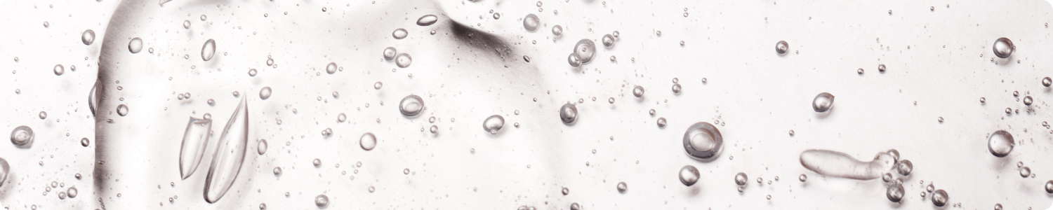 Textuur van een helder, transparant gel-serum met talloze kleine zuurstofbelletjes, representatief voor hyaluronzuur.