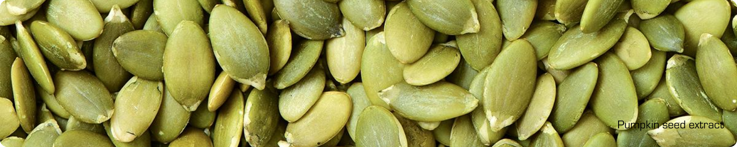 Een bovenaanzicht van een grote hoeveelheid rauwe, donkergroene pompoenpitten die rijk zijn aan mineralen en vitamines voor de huid.