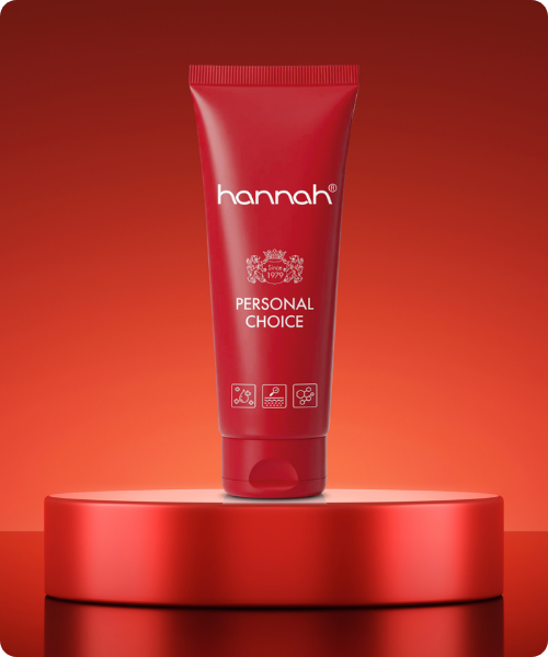 Een tube hannah Personal Choice huidverzorging gepresenteerd op een rood podium tegen een achtergrond in bijpassende rode tinten.
