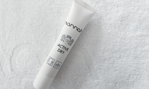 Een witte tube hannah Active Dry liggend op een witte handdoek met reliëf.