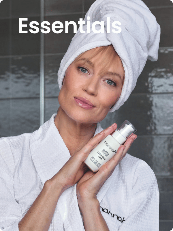 vrouw met handdoek op haar hoofd toont een fles hannah cleansing milk