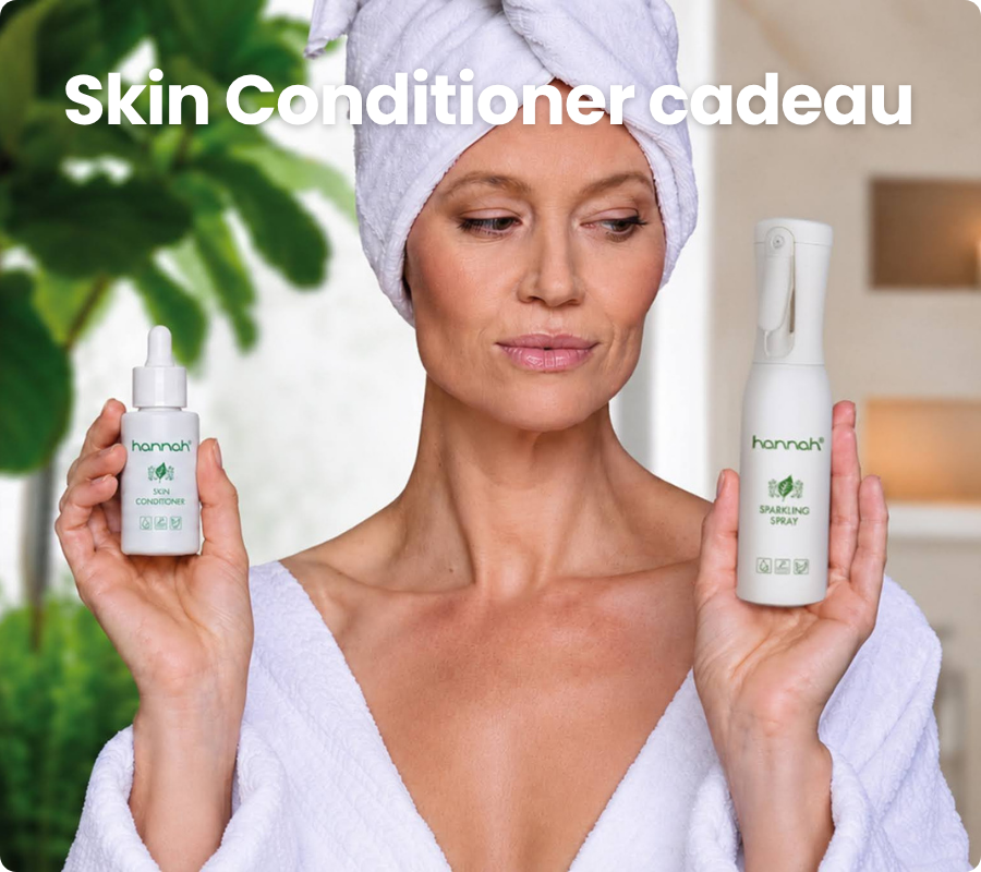 Een vrouw met een handdoek op haar hoofd toont hannah skin conditioner en hannah sparkling spray in een spa setting, met de nederlandse tekst Skin Conditioner cadeau erboven.